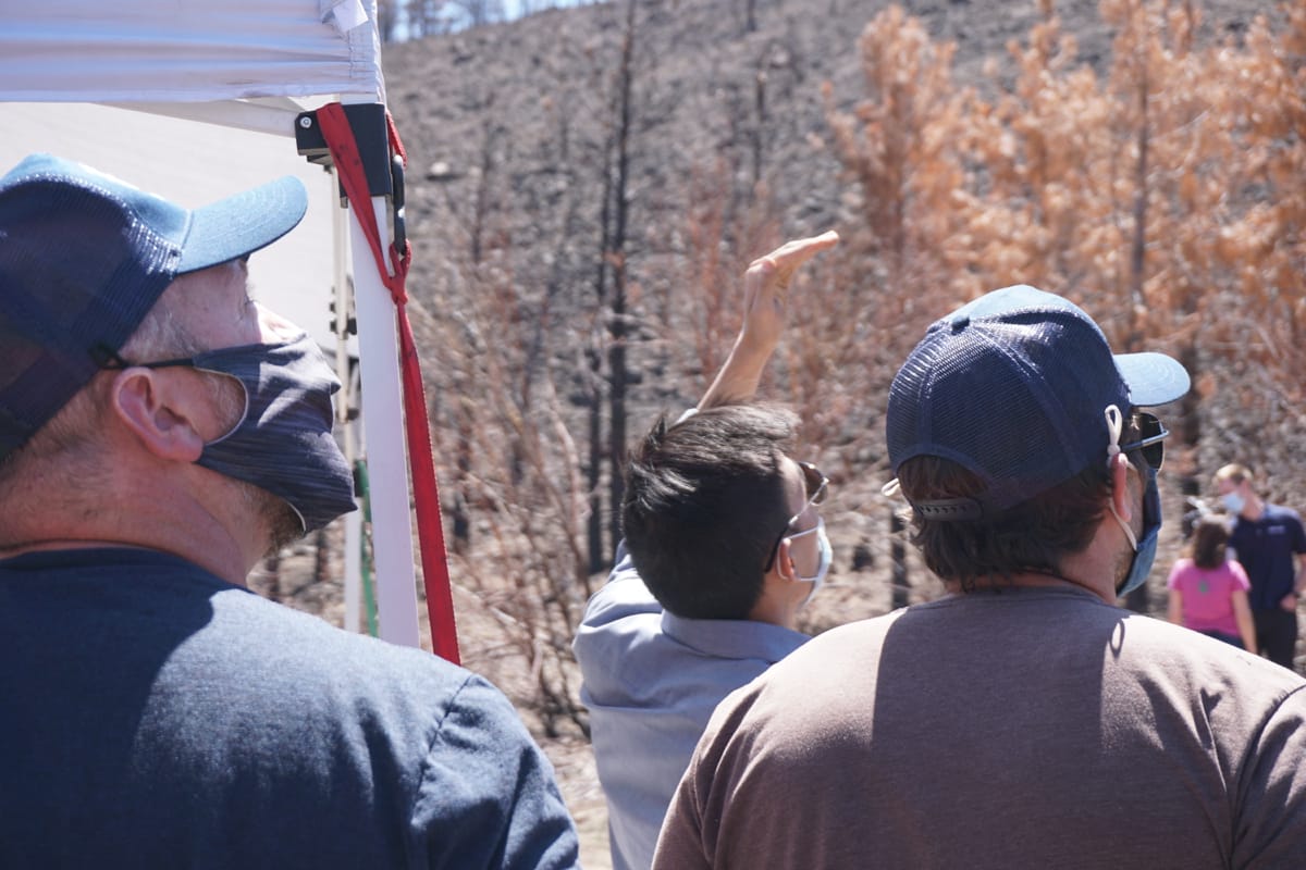 Personnel from the Desert Research Institute and Flying Forests watch a drone take off on a reseeding flight at the Loyalton Fire burn area on April 22, 2021.