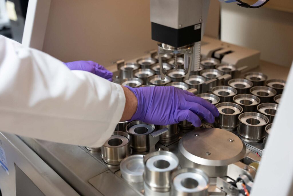 Researcher in the lab wearing gloves and using equipment.