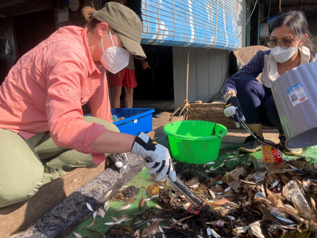 Rachel sorting through plastics from a fisherman's catch in Cambodia